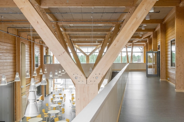Un edificio de muros de troncos macizos y excepcionales pilares de madera laminada - Imagen Principal