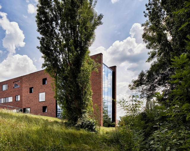 Casa circular de ladrillos con muro de tierra apisonada / AST 77 Architecten - Fotografía exterior, Vivienda Colectiva
